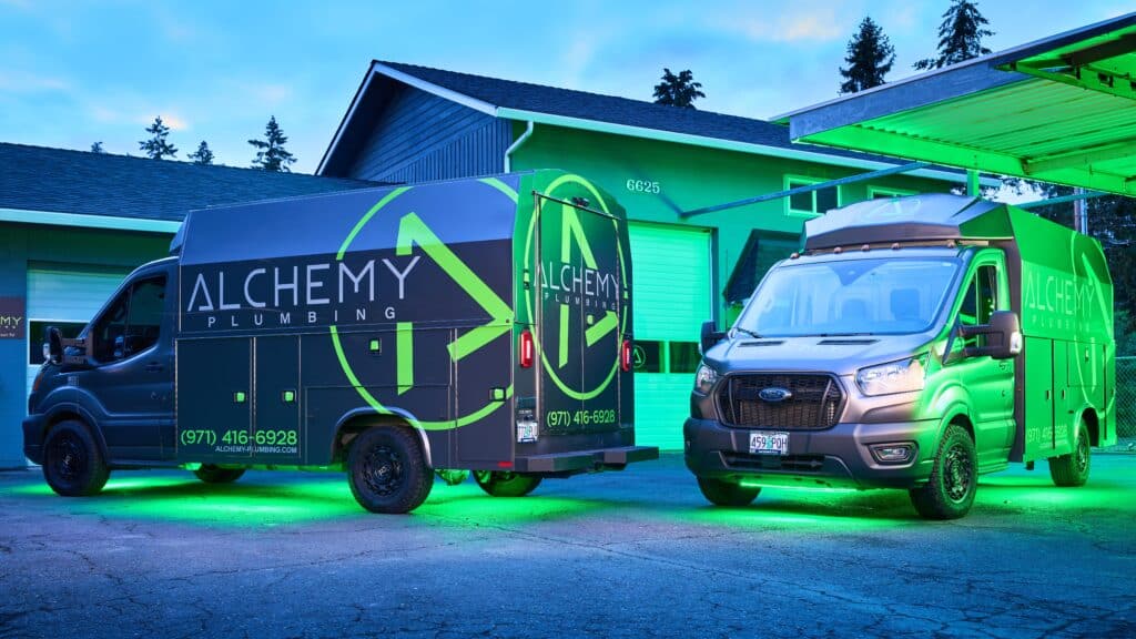 Two Knapheide KUVs with green underbody lighting in the twilight